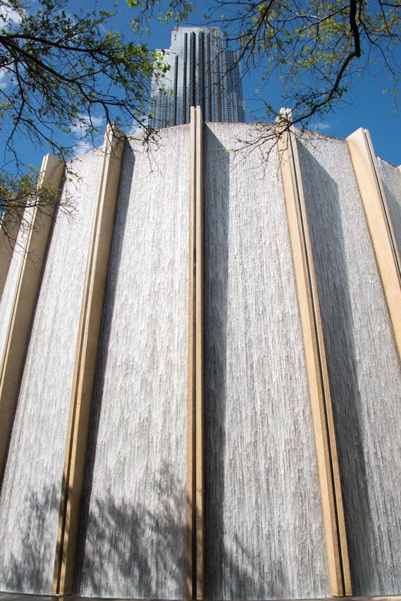 The Gerald D. Hines Waterwall in Houston, Texas, cascading water over its curved concrete facade with a high-rise building behind.